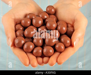 Donna che mantiene MALTESERS AL CIOCCOLATO Foto Stock