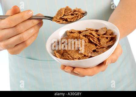 Donna BRANFLAKES mangiare cereali per la prima colazione Foto Stock