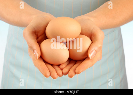 Donna che mantiene le uova di colore marrone Foto Stock