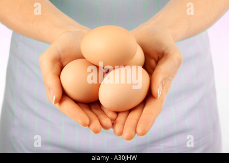 Donna che mantiene le uova di colore marrone Foto Stock