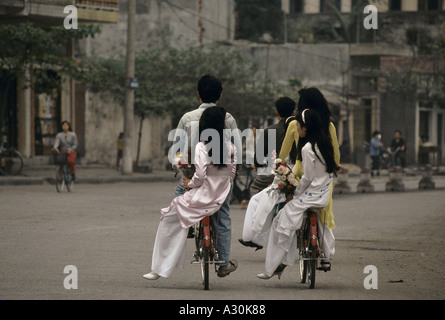 Il Vietnam del Nord Vietnam Halong Bay hon gai città ragazze azienda fiori a cavallo sul retro dei ragazzi biciclette 1994 Foto Stock