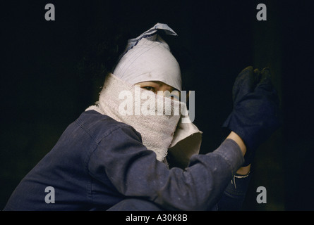 Il Vietnam 1994 Lavoratore che indossa towle come maschera per il viso nella baia di Ha Long shipyard il cantiere è disperata per più ordini di lavoro è la riparazione di navi vecchie 1994 Foto Stock