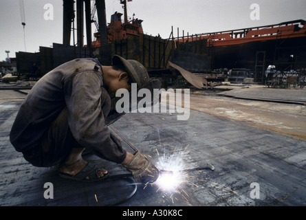 Il Vietnam saldatore nella baia di Ha Long shipyard il cantiere è disperata per più ordini di lavoro è la riparazione di navi vecchie 1994 Foto Stock