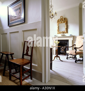Sedia in corridoio con pannelli con vista attraverso la porta di ingresso per soggiorno Foto Stock
