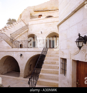 A schiera edificio di pietra esterno con scale e nicchie, Capadocia Turchia Foto Stock