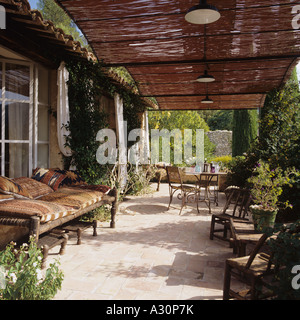 Posti a sedere sulla terrazza pavimentata con coperture in tessuto Foto Stock