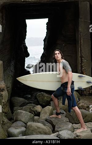Vista di un uomo in possesso di una tavola da surf. Foto Stock