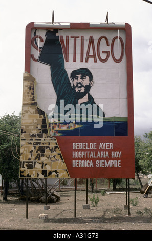 Affissioni raffigurante Fidel Castro tenendo una mitragliatrice aloft e patriottica parole qui sotto come sempre ribelle, Santiago, Cuba Foto Stock