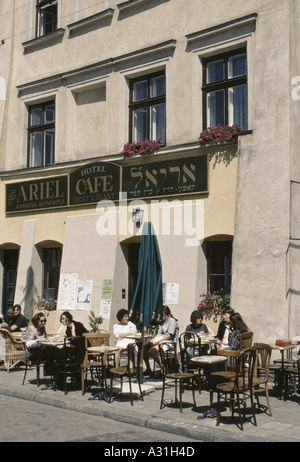 La gente seduta ai tavoli sulla strada fuori dell'Ariel cafe in kazimierz un vecchio quartiere ebreo abbandonato dopo olocausto utilizzato come location per Schindler's list 1995 Foto Stock