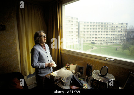 Il vecchio donna che guarda fuori dalla finestra del suo appartamento su Chalk Hill Station wagon Foto Stock