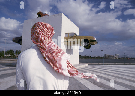 Arabia Saudita un uomo arabo cercando su di una moderna scultura in Jeddah Foto Stock