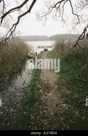 Piccole casette di legno barca a remi legati alla sulla riva di un lago nella regione mazury Foto Stock