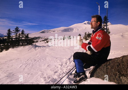 Backcountry rider prendendo pausa sulla strada per il cratere del lago della Baia di Hudson Mountain Smithers Columbia britannica Foto Stock