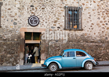 Messico San Miguel De Allende Blue Volkswagen maggiolino auto parcheggiate su street coffee shop persone e cane stand in porta per memorizzare Foto Stock