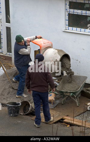 Due costruttori usando un mescolatore di cemento sullo sviluppo di nuove case in Cornovaglia,Inghilterra Foto Stock