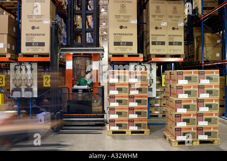 Il magazziniere il funzionamento di un carrello elevatore a forche in un rack del magazzino, Germania Foto Stock