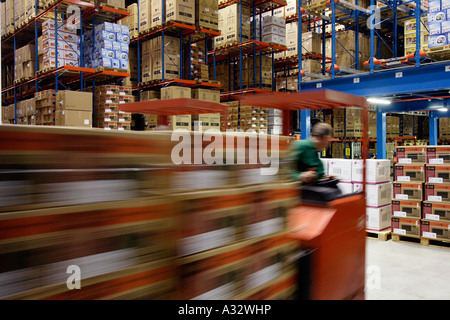 Il magazziniere il funzionamento di un carrello elevatore a forche in un rack del magazzino, Germania Foto Stock