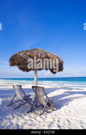 Spiaggia caraibica scena con due sedie sotto la palapa ombra vicino a Cancun, Messico. Foto Stock
