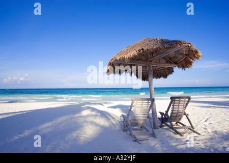 Spiaggia caraibica con due sedie sotto ombra palapa. Tulum, Messico, Quintana Roo Foto Stock