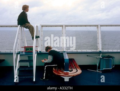 Due giovani ragazzi su una nave traghetto della Reederei linea di colore Foto Stock