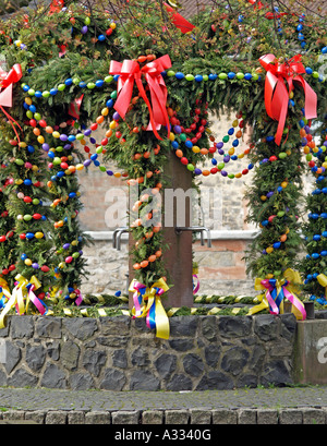 Decorazione per Pasqua un ben fontana decorata con festoni e ghirlande di vistosi le uova in diversi colori Foto Stock