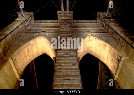 Una vista notturna della torre ovest del ponte di Brooklyn a Manhattan New York City USA nota il web di cavi di questa famosa Foto Stock