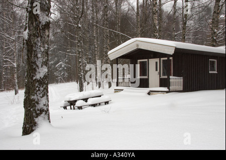 Norvegia, Oslo Oslo City. Coperta di neve in legno capanna campeggio / cabina in Bogstad campeggi in Oslo city. Foto Stock