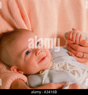 Close up di un giovane bambino essendo trattenuto dalla sua madre Foto Stock