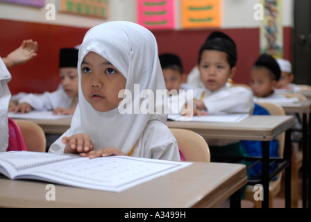 Uno primario e asilo gli studenti che studiano una versione semplificata del Corano presso una scuola musulmana, Kuala Lumpur, Malesia Foto Stock