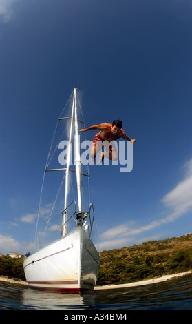 L'uomo immersioni dalla barca in mare blu Foto Stock