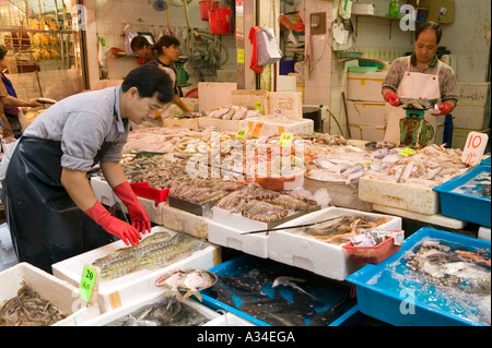 L'uomo preparazione del pesce per la vendita nel mercato di strada , Hong Kong , Cina Foto Stock
