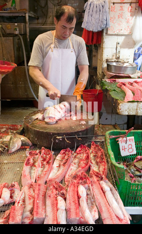 L'uomo preparazione del pesce per la vendita nel mercato di strada , Hong Kong, Cina. Foto Stock