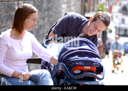 Royalty free fotografia di British coppia giovane con il bambino nel passeggino godendo una giornata fuori in London REGNO UNITO Foto Stock