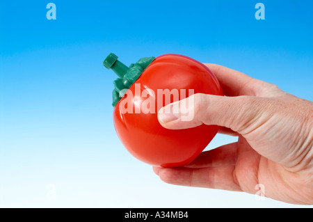 Schiacciamento mani tomato ketchup bottiglia Foto Stock