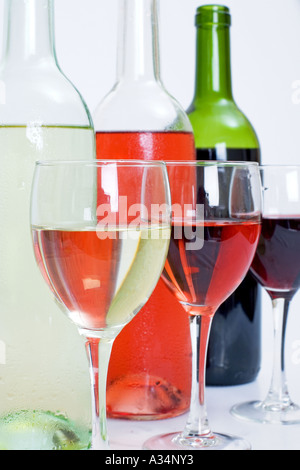 3 bottiglie e 3 bicchieri di vino bianco incluso rosa e rosso tutte isolate Foto Stock