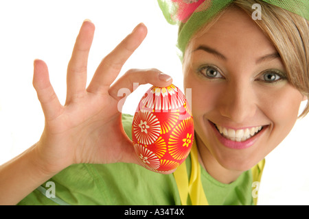 Sorridente giovane donna holding multicolore di uovo di pasqua Foto Stock