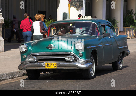 Classico verde taxi parcheggiato sul ciglio della strada, Havana, Cuba Foto Stock