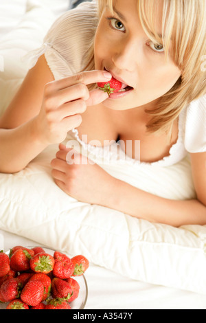Giovane donna di mangiare fragole Foto Stock