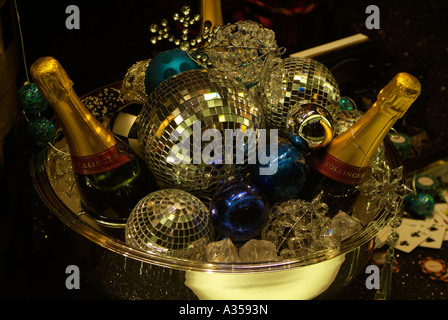 Due bottiglie di champagne in una ciotola con le decorazioni di Natale sulla visualizzazione in una finestra del negozio. Foto Stock