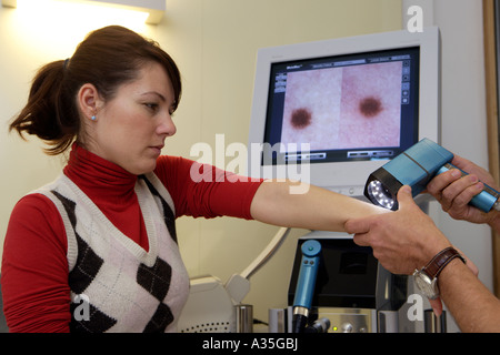 Il specialista di pelle MD Serko von Schmiedeberg esamina un paziente con un video dermatoscope Foto Stock