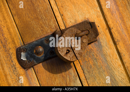 Chiusura del lucchetto arrugginito su una porta di legno Foto Stock