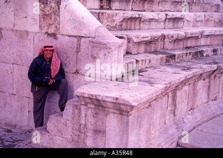 Steve un funzionario Tour Guida all'Anfiteatro romano di Amman in Giordania che indossano il tradizionale Jordanian Keffiyeh panno di testa Foto Stock