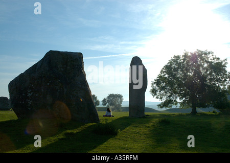 Meditando all'alba all'alba ad Avebury Circle NEL REGNO UNITO, uno del più grande deuropa circoli di pietra - più vecchi di Stonehenge Foto Stock