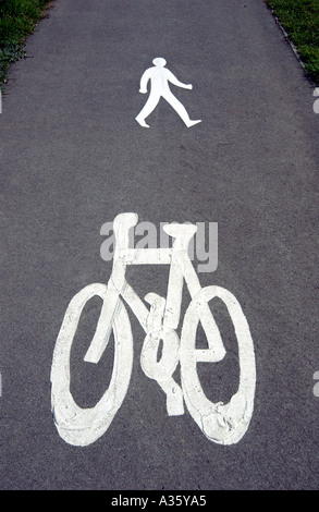 Un segno bianco verniciato sulla strada o marciapiede indicando un pedone e ciclista o di attraversamento del percorso a piedi Foto Stock