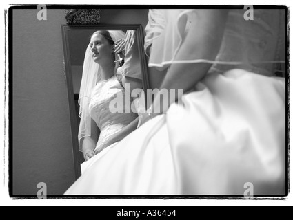 Sposa è riflessa in uno specchio come i suoi capelli è fatto prima del matrimonio Foto Stock