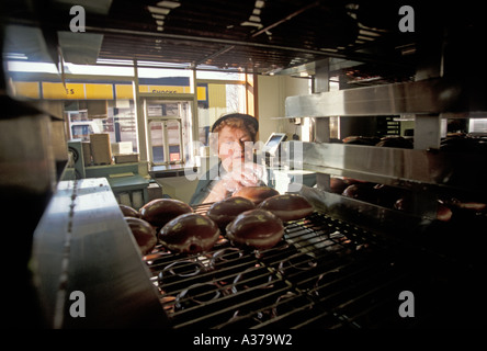 Warren Michigan Virginia Gaer 77 preleva le ciambelle off vassoi per un cliente al Krispy Kreme donut shop Foto Stock