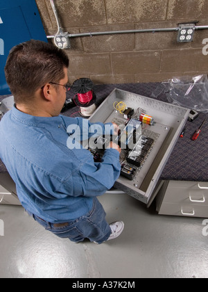 Maschio del cablaggio per il tecnico elettronica e filo in un gruppo del pannello di controllo su un banco di lavoro Foto Stock