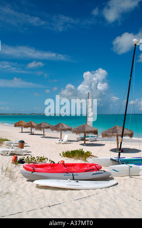 Barca kayak e ombrelloni di paglia sulla spiaggia il Sands Resort Provo Providenciales Isole Turks e Caicos Foto Stock