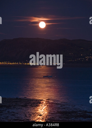 Luna si elevano al di sopra di MENAI stretto con la luna piena al di sopra di Tal y ventola da Beaumaris Anglesey North Wales UK Foto Stock