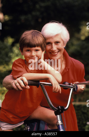 Ritratto di 5 anno vecchio ragazzo seduto sulla bicicletta accanto alla nonna Foto Stock